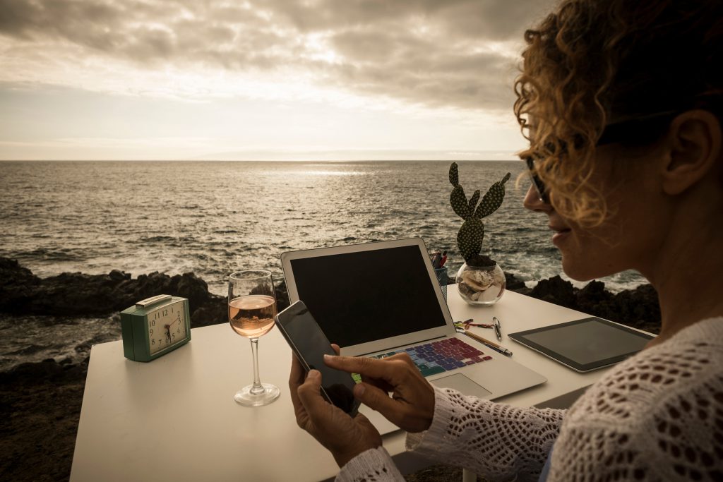 beautiful assistant professional lady at work in alternative freedom concept office in front of the ocean. enjoy a different lifestyle and work with social media like digital nomad